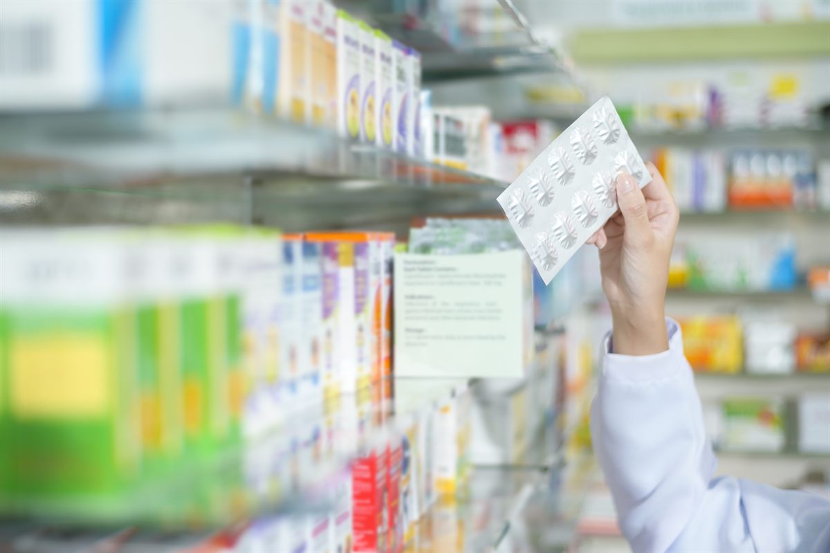 Farmacéutica seleccionando producto en una farmacia surtida